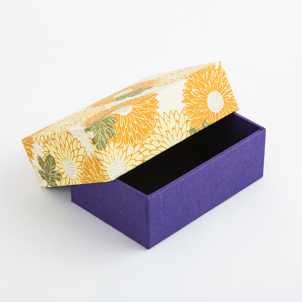 Imagem de caixa de chiyogami com desenho de crisântemos amarelos.