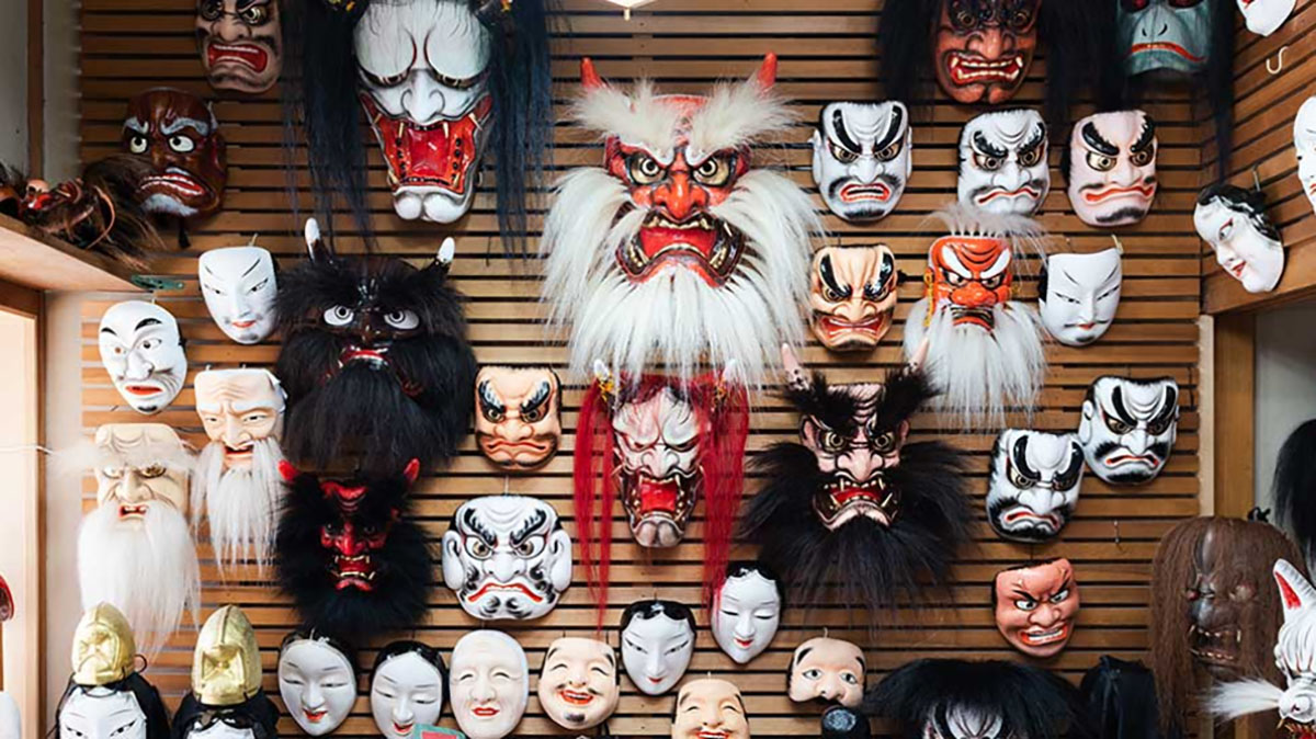 Fotografia de  máscaras usadas nas apresentações de Iwami Kagura expostas em uma parede. 