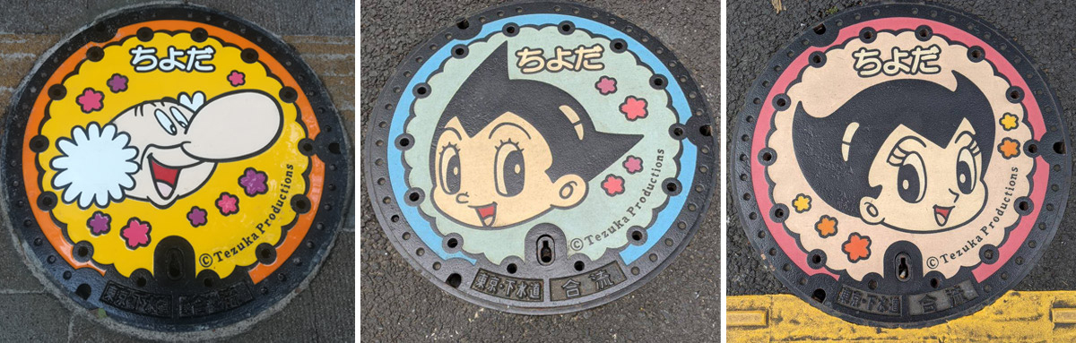 Três tampas de bueiro coloridas do Astro Boy em Chiyoda-ku, Tóquio, Tezuka Productions©