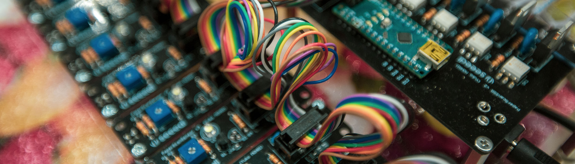 Foto de detalhe de fios coloridos e placas de programação.
