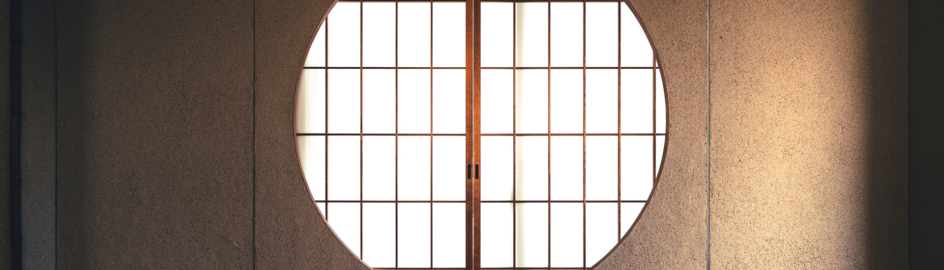 Janela redonda com portas de papel em sala japonesa.