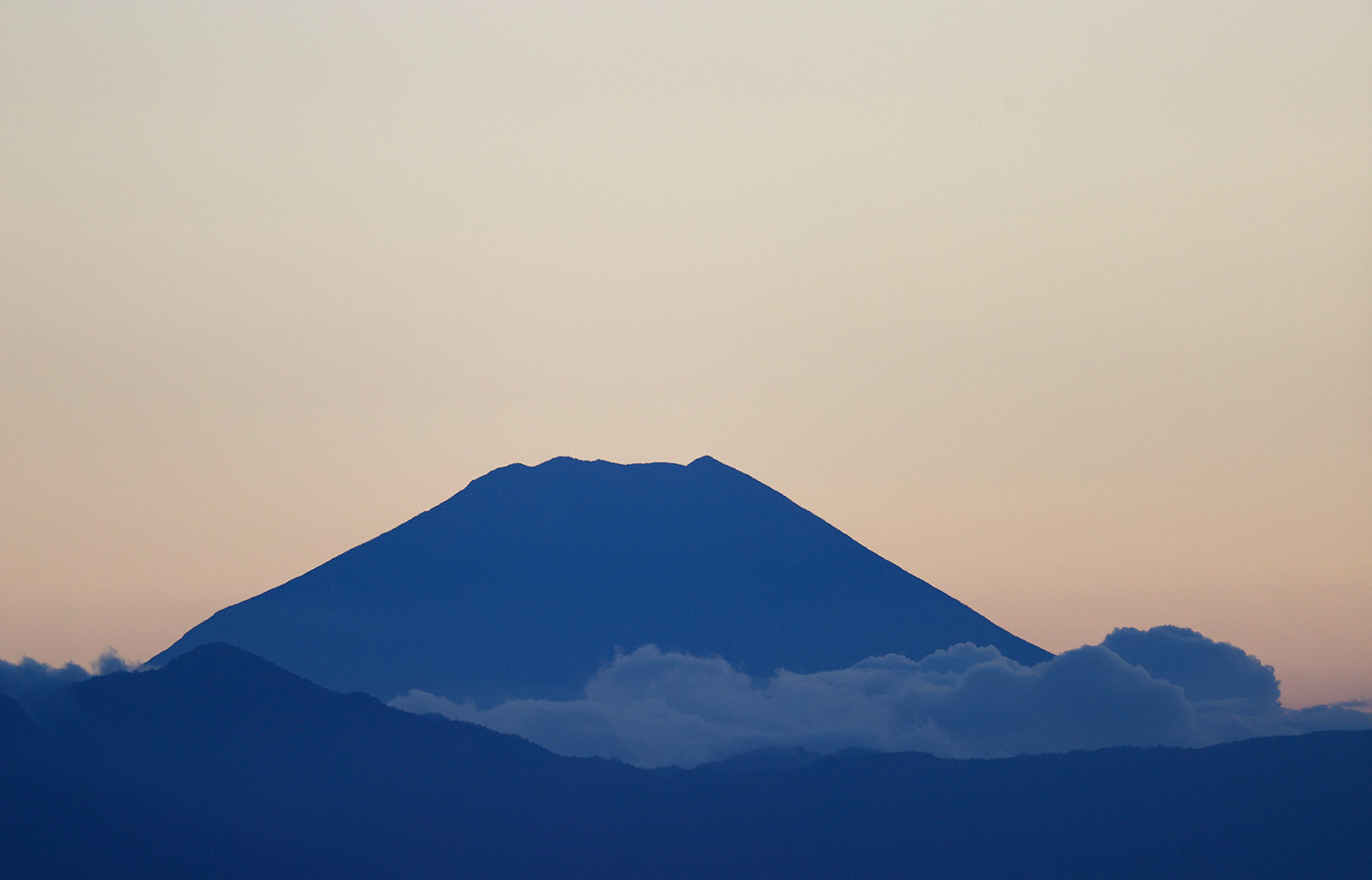 Monte Fuji em tons de azul, com céu rosado ao fundo.