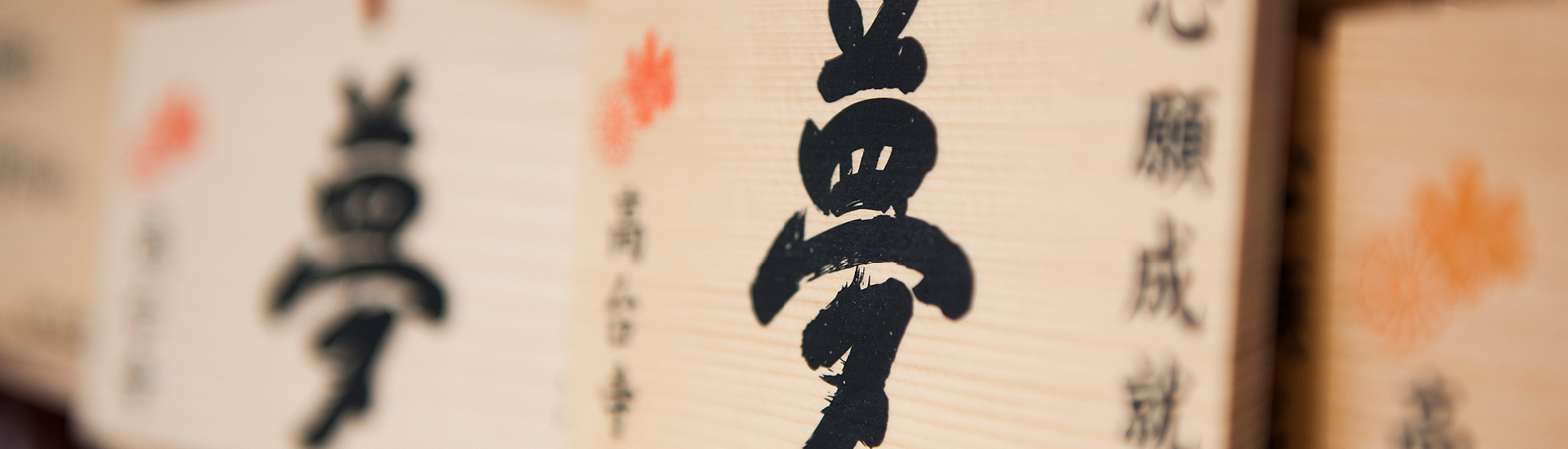 Ema: as Oferendas Feitas em Santuários Xintoístas. Na foto, detalhe de placas de madeira com ideogramas japoneses escritos em tinta preta.