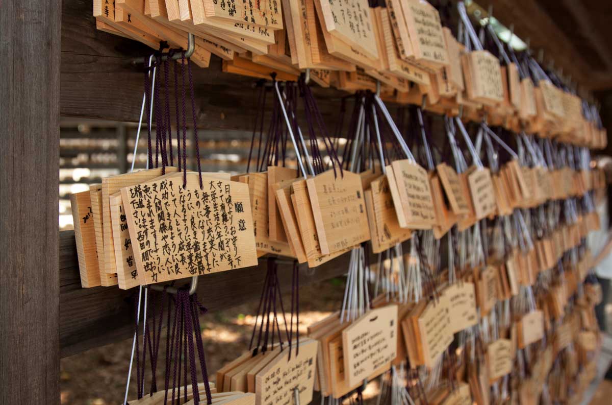 Ema: as Oferendas Feitas em Santuários Xintoístas. Na foto, detalhe de placas de madeira com ideogramas japoneses escritos em tinta preta.