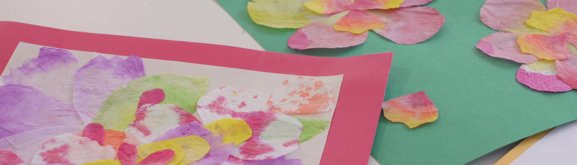 Detalhes de pétalas de papel nas cores rosa, amarelo, verde e lilás.