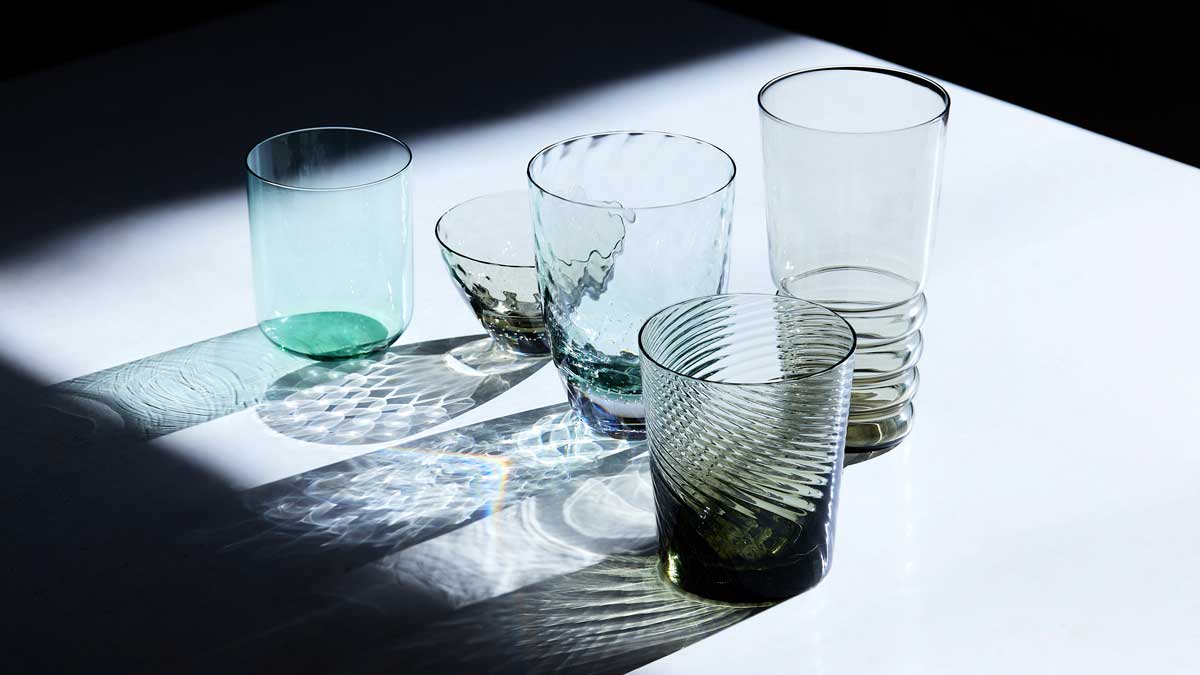 Edo Glass: recipientes de vidro sobre mesa branca.