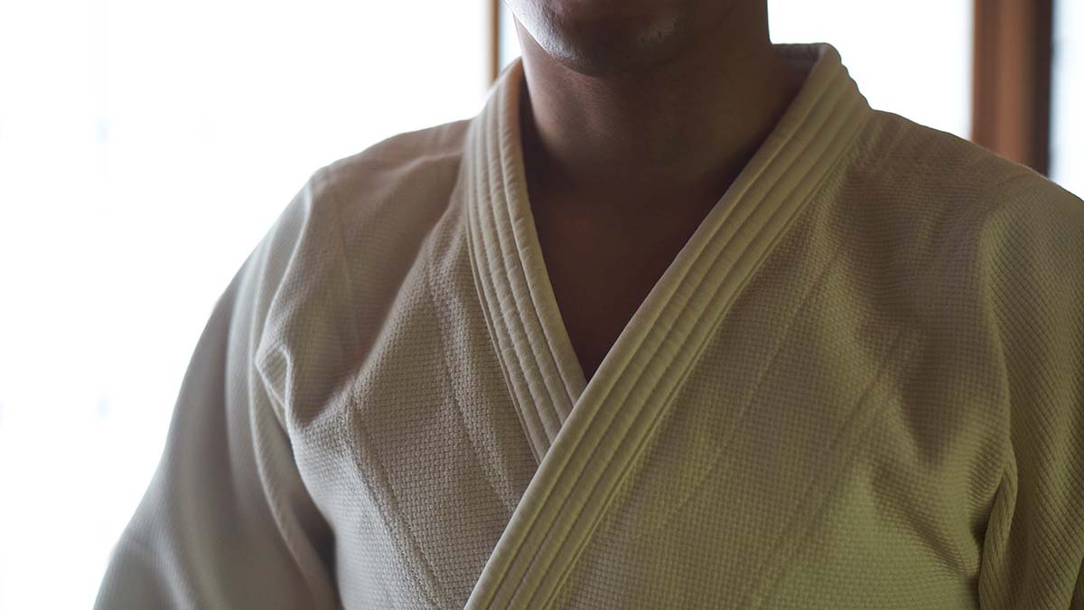 Imagem colorida do busto de uma pessoa vestindo um judogi branco