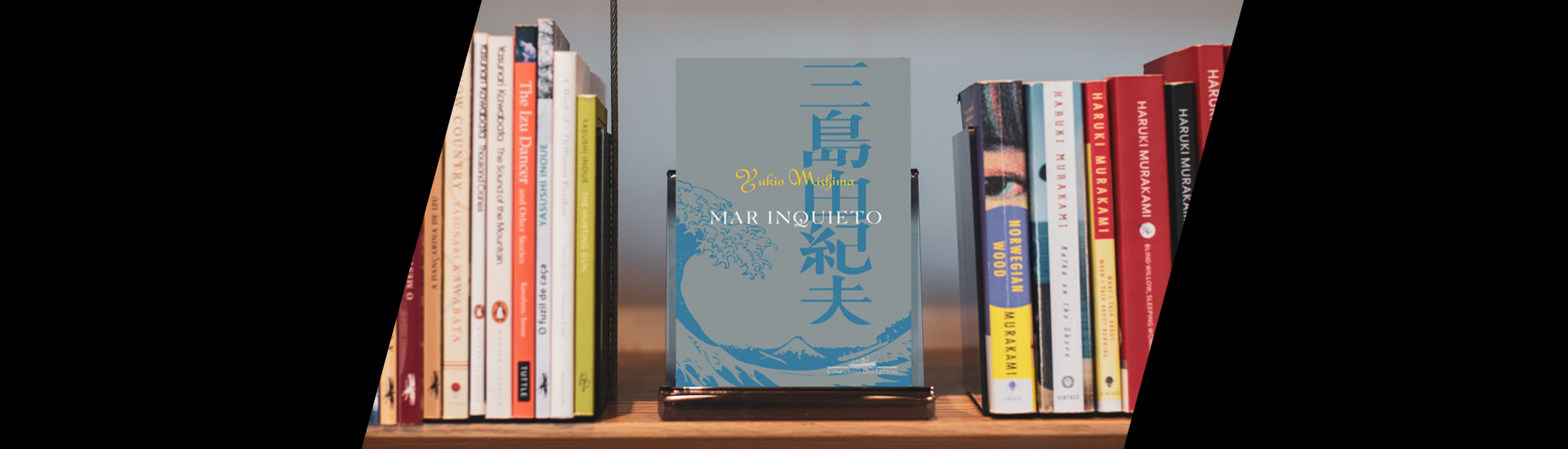 Prateleira de livros destacando 'Mar Inquieto', de Yukio Mishima, ao centro. 