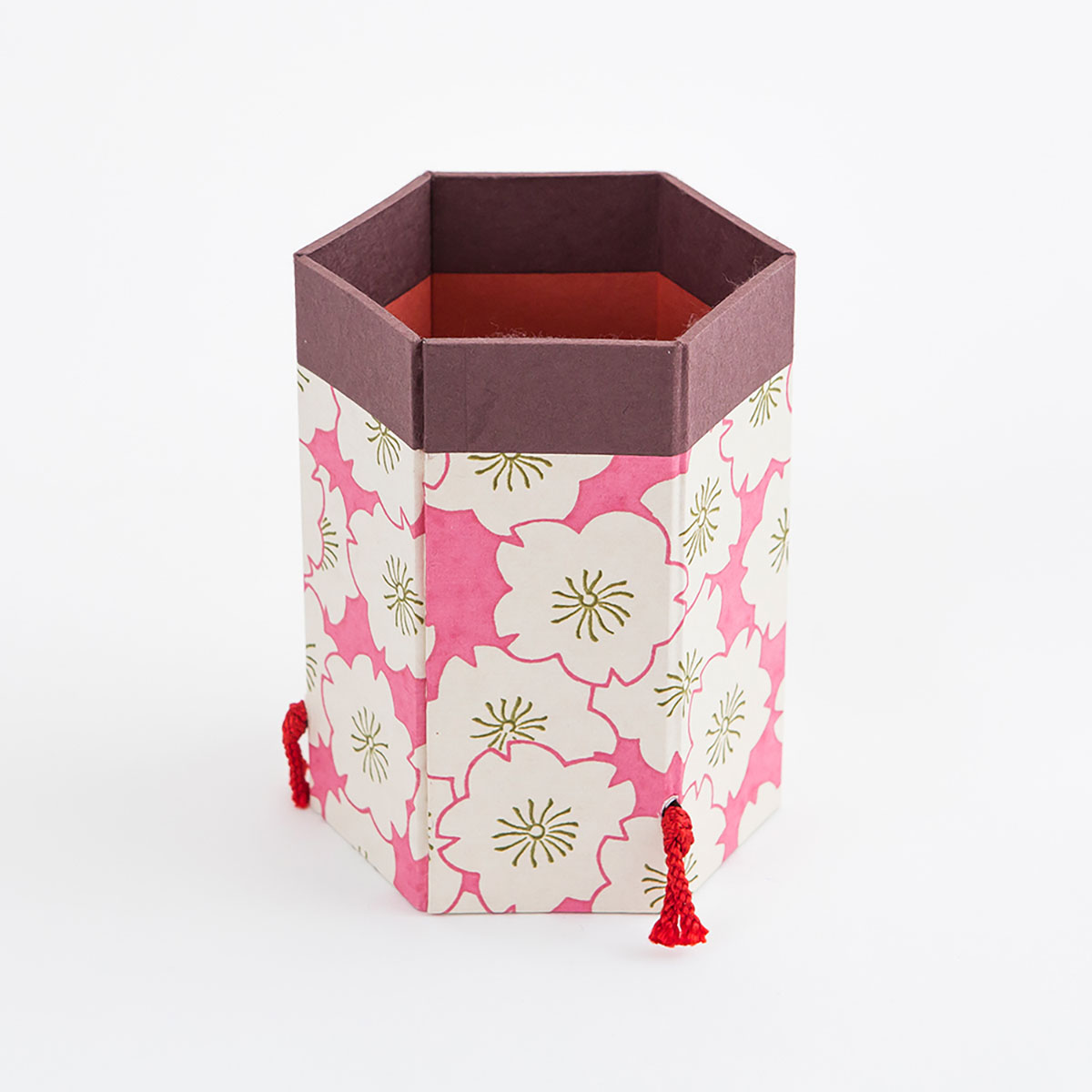 Imagem de Um suporte de caneta e uma pequena caixa em chiyogami de sakura rosa. 