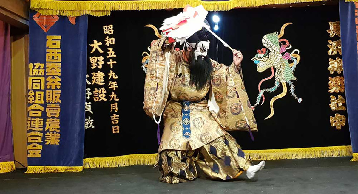 magem de uma pessoa usando máscara em uma  apresentações de Iwami Kagura