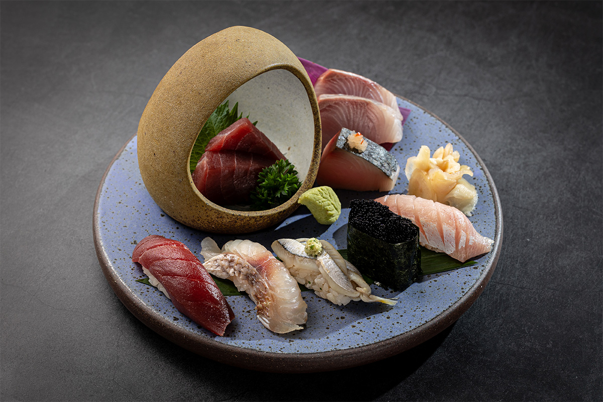 Fotografia de diversos sushis dispostos em prato de cerâmica azul.