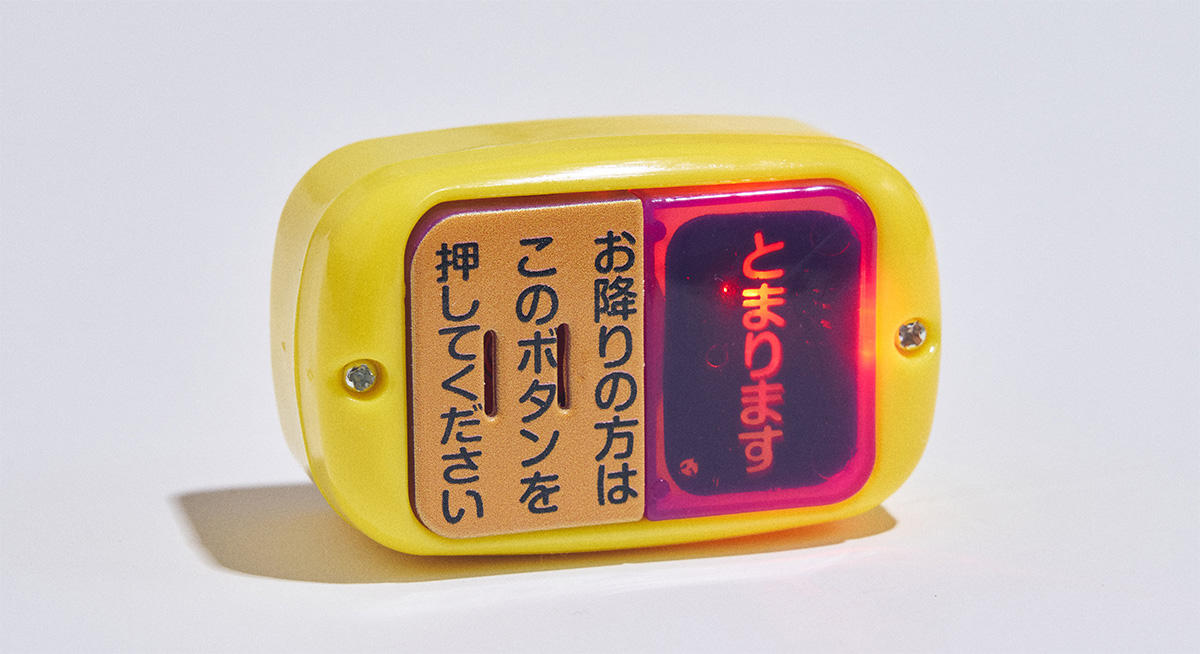 Brinquedo de máquina simulando um botão de parada solicitada dos ônibus japoneses