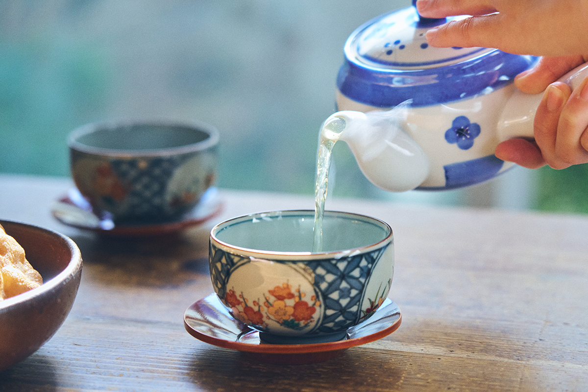 Foto com detalhe de um bule japonês servindo chá
